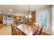 Elegant dining room featuring a glass-top table and chairs, flowing into a modern kitchen with wood cabinets and recessed lighting at 5448 El Diente St, Golden, CO 80403