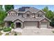 Beautiful two-story home featuring a stone and stucco facade, three-car garage, and solar panels at 5448 El Diente St, Golden, CO 80403