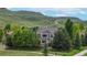 Beautiful two-story home with many trees, fenced yard, and close to green hills in the background at 5448 El Diente St, Golden, CO 80403