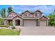 Stately home with three-car garage, stone accents, and mature landscaping, showcasing elegance and curb appeal at 5448 El Diente St, Golden, CO 80403