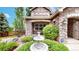 Charming home with manicured landscaping, a water fountain feature, and a stone exterior, offering inviting curb appeal at 5448 El Diente St, Golden, CO 80403