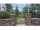 Stone pillar gate surrounded by lush greenery and manicured garden beds, offering a private outdoor sanctuary at 5448 El Diente St, Golden, CO 80403