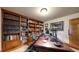 Cozy home office featuring custom built-in bookshelves and a large desk, providing an inspiring workspace at 5448 El Diente St, Golden, CO 80403