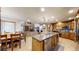 Open concept kitchen with stainless steel appliances, a large island, and seamless flow to the living area at 5448 El Diente St, Golden, CO 80403