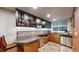 Basement wet bar area featuring dark cabinets and stainless steel appliances at 5448 El Diente St, Golden, CO 80403