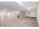 Expansive basement area with light wood flooring and staircase to the main level at 56159 E Tomahawk Ave, Strasburg, CO 80136
