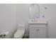 Half-bathroom features a white vanity, toilet, and contemporary fixtures against a clean, minimalist backdrop at 56159 E Tomahawk Ave, Strasburg, CO 80136