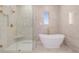Luxurious bathroom showcasing a standalone tub, glass-enclosed shower with seat, and upscale finishes at 56159 E Tomahawk Ave, Strasburg, CO 80136