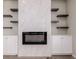 Contemporary fireplace features white marble surround and custom built-in shelving at 56159 E Tomahawk Ave, Strasburg, CO 80136