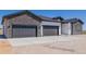 New home exterior showing attached three-car garage with stone and white siding at 56159 E Tomahawk Ave, Strasburg, CO 80136