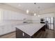 Bright kitchen showcases white cabinets, stainless steel appliances, a large island, and elegant pendant lighting at 56159 E Tomahawk Ave, Strasburg, CO 80136
