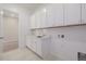 Bright laundry room with white cabinets and quartz countertops at 56159 E Tomahawk Ave, Strasburg, CO 80136