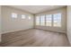 Sunlit living room with hardwood floors and large windows offering picturesque views of the surrounding landscape at 56159 E Tomahawk Ave, Strasburg, CO 80136