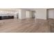 View of the home's open floor plan with hardwood floors connecting living and kitchen areas at 56159 E Tomahawk Ave, Strasburg, CO 80136