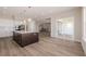 View of open kitchen and living area, showcasing hardwood floors and stainless appliances at 56159 E Tomahawk Ave, Strasburg, CO 80136