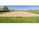 Outdoor sand volleyball court with net and surrounding green grass at 56159 E Tomahawk Ave, Strasburg, CO 80136
