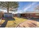 Spacious backyard with mature tree and brick-paved patio at 971 Elm Pl, Thornton, CO 80229