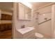 Bright bathroom with tile shower, white fixtures, a mirrored cabinet, and adjacent wood-floored kitchenette at 971 Elm Pl, Thornton, CO 80229
