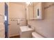 Neat bathroom with towel rack, tiled walls, a single sink vanity, and a mirrored medicine cabinet at 971 Elm Pl, Thornton, CO 80229