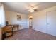 Well-lit bedroom featuring neutral carpet, ceiling fan, and adjacent room access at 971 Elm Pl, Thornton, CO 80229