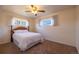 Comfortable bedroom featuring a full bed, ceiling fan, and natural light from two windows at 971 Elm Pl, Thornton, CO 80229