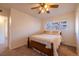 Bright bedroom featuring a ceiling fan, a cozy bed, and a window offering neighborhood views at 971 Elm Pl, Thornton, CO 80229