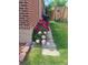Charming home landscaping with beautiful pink peonies along the stone path and red brick wall at 971 Elm Pl, Thornton, CO 80229