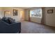 Inviting living room with plush carpeting, a comfortable sofa, and a large window with natural light at 971 Elm Pl, Thornton, CO 80229