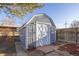 Backyard storage shed with a double door entrance and garden at 971 Elm Pl, Thornton, CO 80229