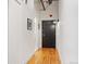 A bright hallway featuring hardwood floors, leading to an entrance door with stylish black hardware at 1801 Wynkoop St # 518, Denver, CO 80202