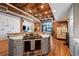 Wide kitchen view with an island cooktop, steel appliances, exposed pipes and ducts, and light from a large window at 1801 Wynkoop St # 518, Denver, CO 80202