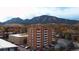 Stunning aerial view of a brick apartment building with breathtaking mountain views in the background, showcasing the beauty of the location at 850 20Th St # 503, Boulder, CO 80302