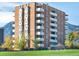 Multi-story brick building featuring balconies and mountain views set against a bright blue sky at 850 20Th St # 503, Boulder, CO 80302