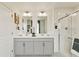 Well-lit bathroom featuring a glass shower, dual sinks, and a vanity at 18813 E 99Th Ave, Commerce City, CO 80022