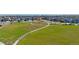 An aerial view shows a large community green space with walking paths lined with new homes at 18813 E 99Th Ave, Commerce City, CO 80022