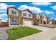 Two-story home with blue shutters, a two car garage, and a newly landscaped yard at 18813 E 99Th Ave, Commerce City, CO 80022