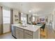 Kitchen with a large island and gray cabinets open to the dining and living area at 18813 E 99Th Ave, Commerce City, CO 80022