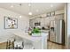 Bright kitchen with gray cabinets, a large island, stainless appliances, and modern pendant lighting at 18813 E 99Th Ave, Commerce City, CO 80022