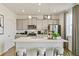 Bright kitchen with gray cabinets, a large island, stainless appliances, and modern pendant lighting at 18813 E 99Th Ave, Commerce City, CO 80022