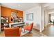 Office with an orange accent wall, desk, shelving, and two orange armchairs at 18813 E 99Th Ave, Commerce City, CO 80022