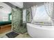 Modern bathroom featuring a luxurious soaking tub, and a glass-enclosed shower with beautiful tile work at 271 Terra Vista St, Brighton, CO 80601