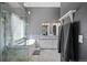 Spa-like bathroom featuring a freestanding tub, modern fixtures, glass shower, and gray color tones at 271 Terra Vista St, Brighton, CO 80601