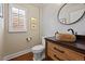 Stylish powder room with stone sink, wood cabinet, and modern fixtures at 520 Jackson St, Denver, CO 80206