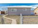 House exterior with a walkway and chain link fence at 5511 Leyden St, Commerce City, CO 80022