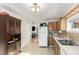 Kitchen with wood cabinets, white appliances and view to living room at 5511 Leyden St, Commerce City, CO 80022