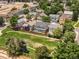 A beautiful aerial view shows houses with lush green trees surrounding a large grass-covered park at 1359 S Beeler Ct, Denver, CO 80247
