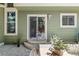Outdoor patio with dining set and potted plants, complemented by the home's green exterior at 1359 S Beeler Ct, Denver, CO 80247