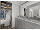 Bathroom featuring double vanity with marble countertop, ample storage, an ironing board, and a closet with shelves at 1359 S Beeler Ct, Denver, CO 80247
