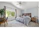 Cozy bedroom featuring a large window, a stylish bed with a wooden headboard, and a vaulted ceiling at 1359 S Beeler Ct, Denver, CO 80247