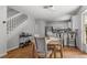 Dining area with a wooden table, chairs, and view into the kitchen and stairway with hardwood flooring at 1359 S Beeler Ct, Denver, CO 80247